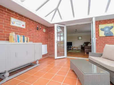 a living room with a couch and a brick wall at Bower View in Hereford