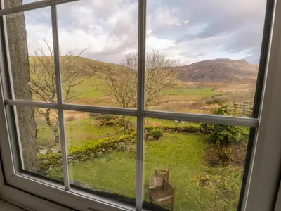 a window view of a field from a house at The Stable Cottage in Llanbedr
