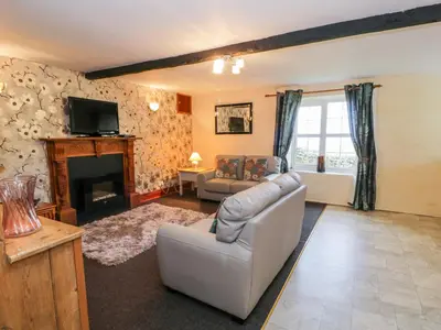 a living room with a couch and a fireplace at The Stable Cottage in Llanbedr