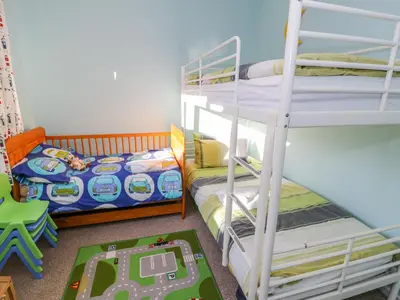 a bedroom with two bunk beds and a childs bed at Clyd Fan in Harlech