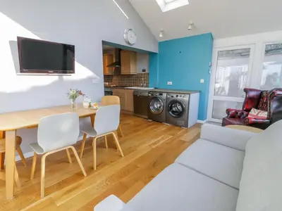 a dining room and living room with a table and chairs at Clyd Fan in Harlech