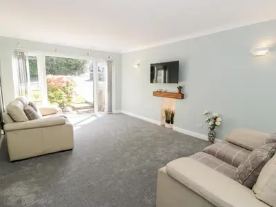 a living room with two couches and a tv at Clyd Fan in Harlech