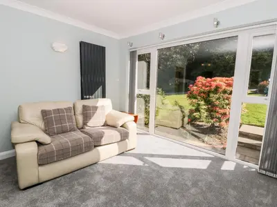 a living room with a couch and a sliding glass door at Clyd Fan in Harlech
