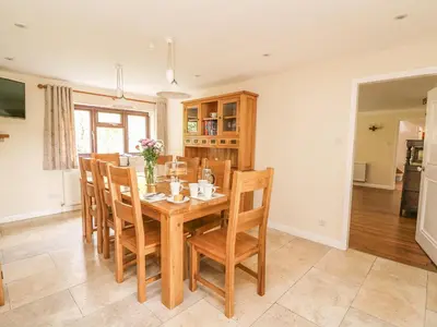 a dining room with a wooden table and chairs at Treboeth in Knighton