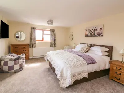 a bedroom with a large bed and a window at Treboeth in Knighton