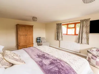 a bedroom with a large bed and a window at Treboeth in Knighton