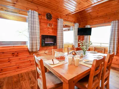 a wooden dining room with a wooden table and chairs at Pines Pitch in Knighton