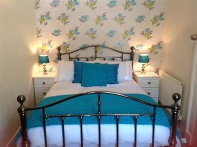 a bedroom with a bed with two night stands and two lamps at The New Inn in Oswestry