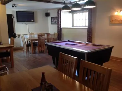 a room with a pool table and a dining room at The New Inn in Oswestry