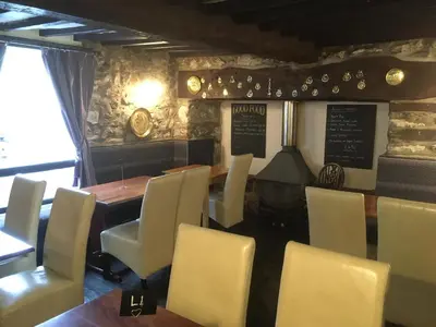 a restaurant with a table and chairs and a piano at The New Inn in Oswestry