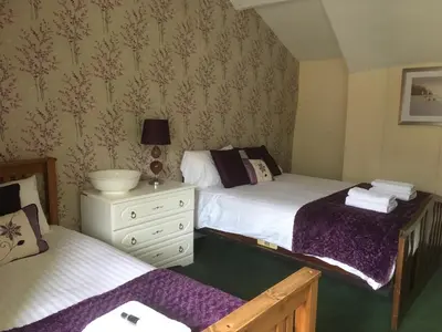 a bedroom with two beds and a white dresser at The New Inn in Oswestry