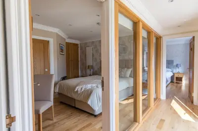 a bedroom with a bed and a room with a mirror at Woodland View Holiday Apartment in Llanwrda