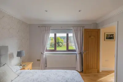 a bedroom with a bed and a window at Woodland View Holiday Apartment in Llanwrda