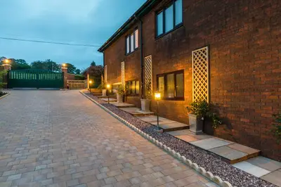 a brick road next to a brick building at Woodland View Holiday Apartment in Llanwrda