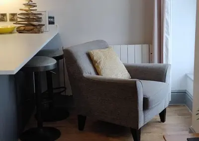 a chair sitting in a kitchen next to a counter at Luxury Sea View Apartment - One Bedroom in Aberystwyth