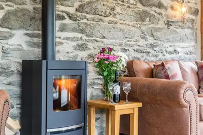 a fireplace in a living room with a couch and flowers at 4 Bed in Bala oc-bow66 in Bala