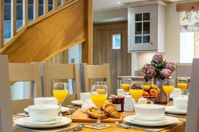 a dining room table with glasses of orange juice at 4 Bed in Bala oc-bow66 in Bala