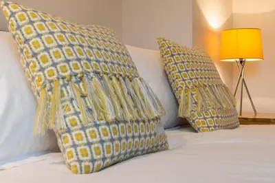 two yellow pillows on a bed with a lamp at 4 Bed in Bala oc-bow66 in Bala
