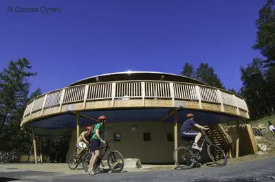 three people riding bikes in front of a circular building at 4 Bed in Bala oc-bow66 in Bala
