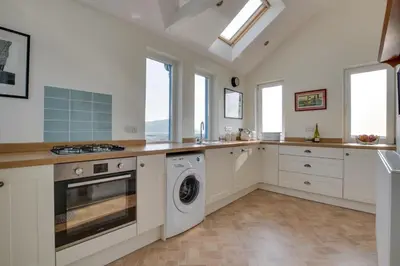 a kitchen with white cabinets and a washer and dryer at 3 Bed in Aberystwyth oc-bow115 in Aberystwyth