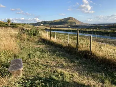 a bench sitting in the grass next to a fence at 3 Bed in Aberystwyth oc-bow115 in Aberystwyth