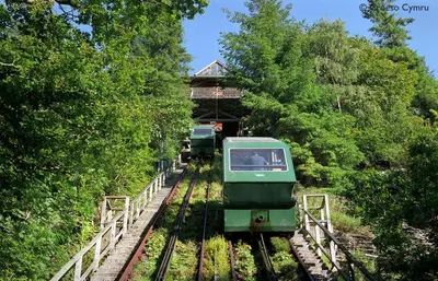 a green train on the tracks with a building at 3 Bed in Machynlleth oc-bow91 in Penegoes