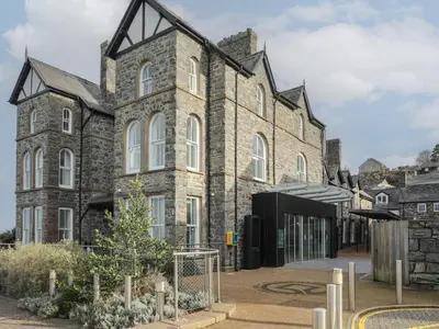 an old stone building with a courtyard in front of it at Harlech Apartments - Branwen in Harlech