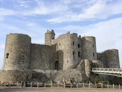 a large castle with two towers and a bridge at Harlech Apartments - Gwern in Harlech