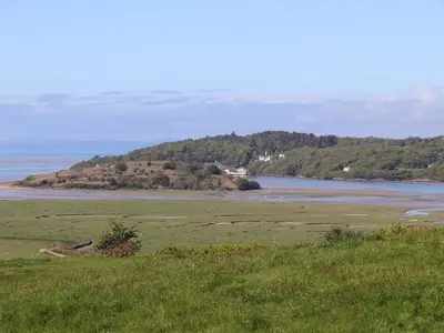 a grassy field with a view of a body of water at Big House in Llandecwyn
