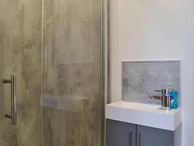 a bathroom with a sink and a shower at Pistyll Gwyn in Llanwrthwl