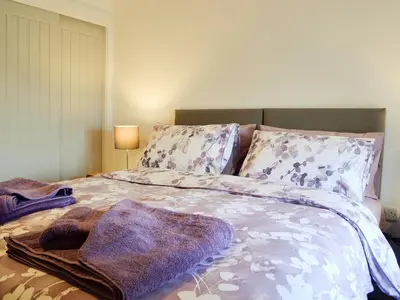 a bedroom with a bed with a blanket and pillows at Pistyll Gwyn in Llanwrthwl