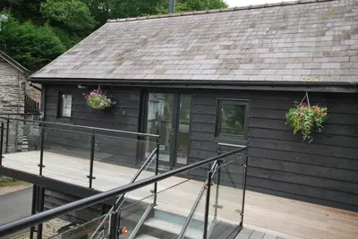 a house with a deck with two plants on it at The Coach House Annexe in Llangollen