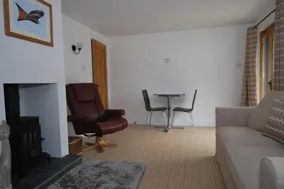 a living room with a couch and a chair and a table at The Coach House Annexe in Llangollen