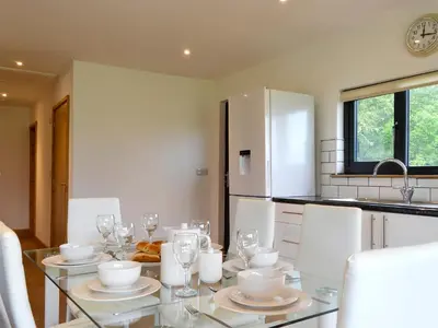 a kitchen with a glass table and white appliances at Offa's Dyke Lodge - Uk10835 in Old Radnor