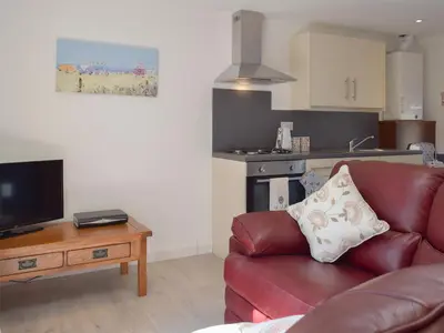 a living room with a red leather couch and a table at Hen Llaeth - Uk11209 in Cwrt-newydd