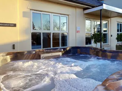 a hot tub in front of a house at Powis Castle View in Forden