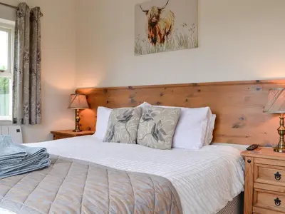 a bedroom with a bed with a wooden headboard at Powis Castle View in Forden