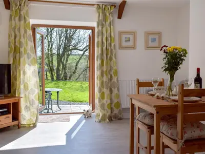 a dining room with a table and a sliding glass door at Parlwr - Uk11210 in Cwrt-newydd
