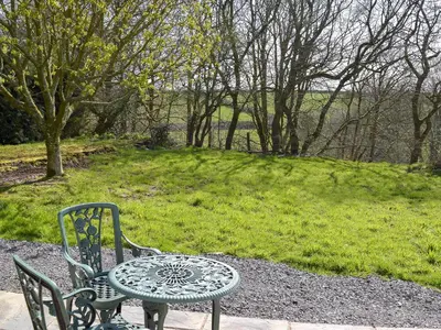 a table and two chairs and a table and a table and chair at Parlwr - Uk11210 in Cwrt-newydd