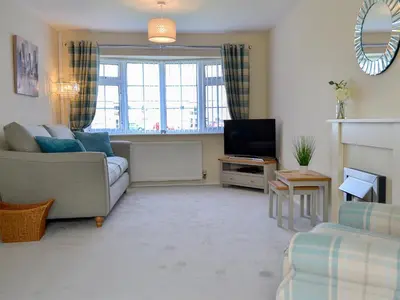 a living room with a couch and a television at Gwynt Y Môr in Tywyn