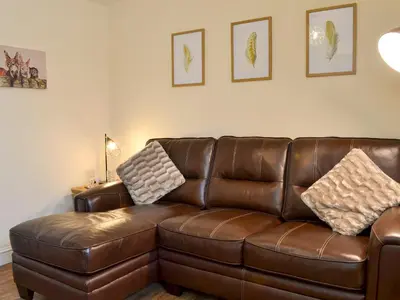 a brown leather couch sitting in a living room at Tyddyn Eli in Llangwm