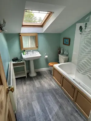 a bathroom with a sink and a tub and a toilet at Cynfaen house in Corwen