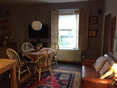 a living room with a table and chairs and a window at Cynfaen house in Corwen