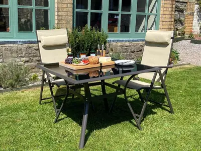 a table with two chairs and a plate of food on it at Tegfan Garden Suite in Talgarth
