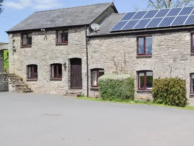 a house with solar panels on the roof at Woodland View-Uk11826 in Llandefaelogfâch