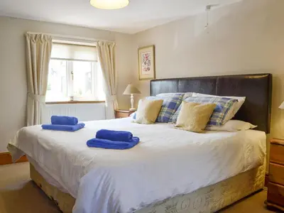 a bedroom with a large bed with blue towels on it at Woodland View-Uk11826 in Llandefaelogfâch