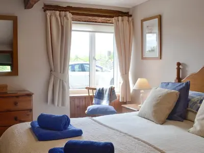 a bedroom with a bed with blue pillows and a window at Woodland View-Uk11826 in Llandefaelogfâch