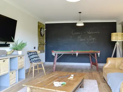 a room with a ping pong table in front of a chalkboard at Maes Y Bryn Farmhouse in Llanwrda