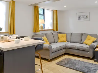 a living room with a gray couch and yellow pillows at Ysgoldy Salem in Mallwyd