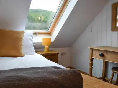 a bedroom with a bed and a window at Ysgoldy Salem in Mallwyd